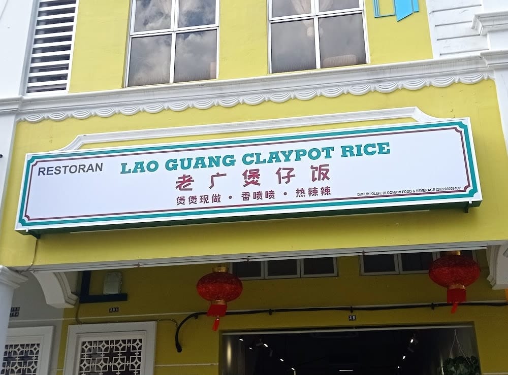 The Lao Guang Claypot Rice shopfront: a white signboard with a teal border on a yellow shophouse